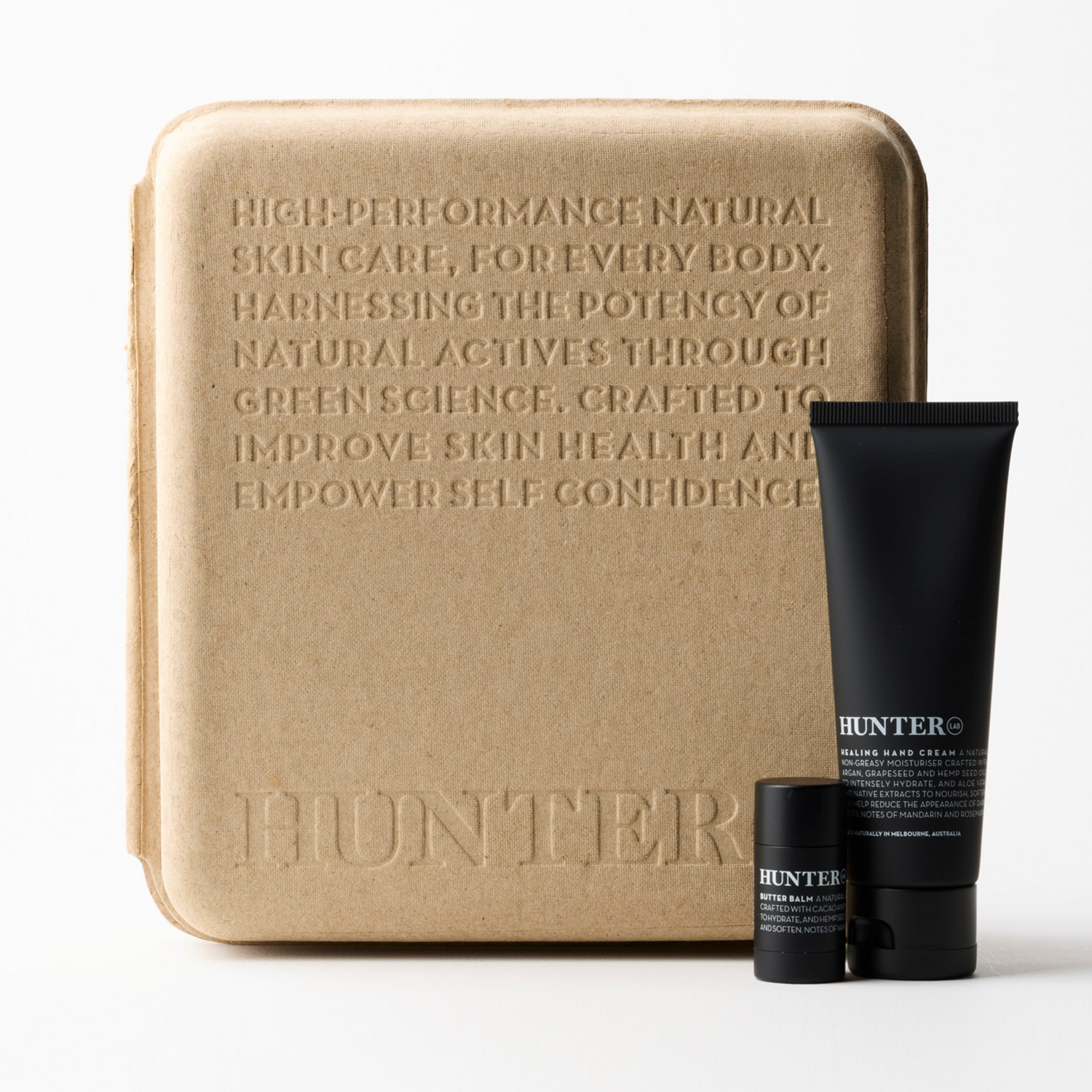 Skincare product set with a beige box and black bottles on a white background